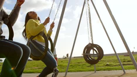 Pareja-feliz-jugando-en-columpio-de-parque-infantil-en-el-Parque-4k