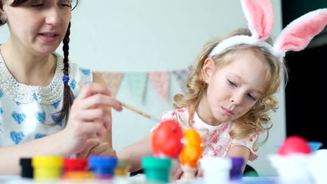 Pequeña-niña-con-la-madre-decoración-de-huevos-de-Pascua