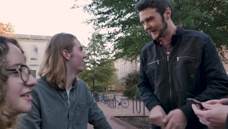 Male-college-student-using-his-hand-to-explain-how-to-use-a-mobile-device