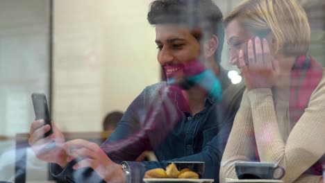 Technology.-Happy-People-With-Mobile-Phone-Having-Fun-In-Cafe