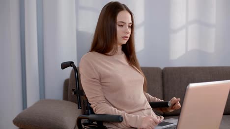 Young-disabled-woman-working-at-home-with-laptop