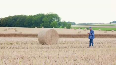 Moderne-Landwirtschaft.-Die-Liebe-zur-Landwirtschaft.-Landwirt-mit-digitalem-Tablet-bei-der-Prüfung-von-Bauernhof