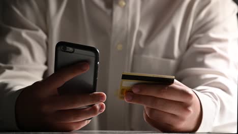 Man-online-banking-using-smartphone-shopping-online-with-credit-card-at-workplace