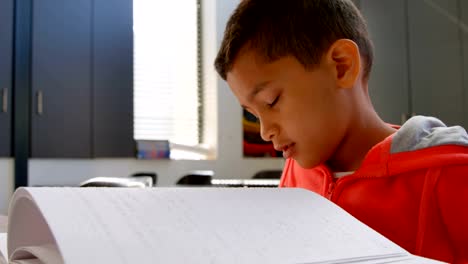 Seitenansicht-blinder-asiatischer-Schuljungen,-die-ein-Braille-Buch-im-Klassenzimmer-der-Schule-4k-lesen