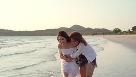 Joven-pareja-lesbiana-asiática-corriendo-en-la-playa.-Hermosas-mujeres-amigas-feliz-relax-divertirse-en-la-playa-cerca-del-mar-cuando-la-puesta-de-sol-en-la-noche.-Lifestyle-pareja-lesbiana-viaje-en-concepto-de-playa.