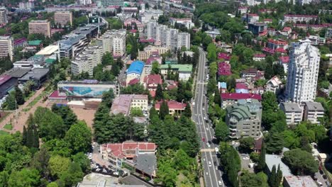 Aerial-video-shooting.-Sochi-city-center-from-a-height.-Panorama-shooting.-Many-houses,-hotels,-hostels-in-the-city-center.-Urban-infrastructure.-Clear-blue-sky.-Metropolis-against-the-mountains.