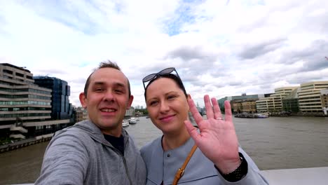 Pareja-tomando-selfie-con-una-vista-del-río-Támesis-y-el-rascacielos-Shard-en-Londres-en-4k-cámara-lenta-60fps