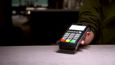 Close-up-shot-of-person-using-terminal-and-credit-card-performing-contactless-payment.