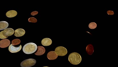 Coins-fall-on-a-black-background.-Slow-motion.