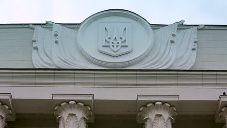 Ukrainisches-Emblem-auf-dem-Parlamentsgebäude.-Wahlhintergrund.-Politisches-Krisenkonzept.-Ukrainische-Werchowna-Rada-Gebäude-Parlamentsgebäude-.-Blick-von-oben-auf-hrushevsky-Straße.