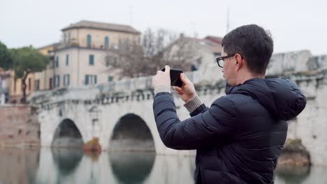 Mann-fotografiert-mit-Smartphone-Brücke