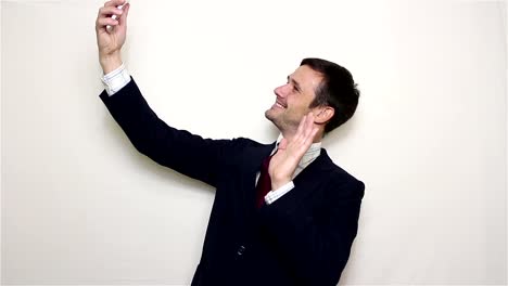 Young-handsome-businessman-making-selfie,-smiling-and-waving-his-hand.