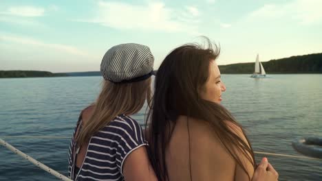 back-view-of-two-lesbians-hugging-and-enjoying-voyage-on-sailboat