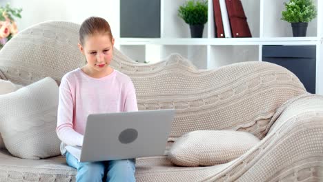 Focused-beautiful-child-girl-chatting-in-social-network-typing-message-using-laptop-pc-medium-shot