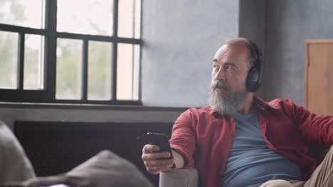 Grey-haired-Bearded-Man-Enjoying-Music-at-Home