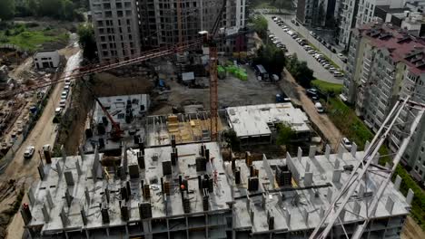 Flight-near-the-unfinished-monolithic-house.-Construction-crane-near-the-construction-site.-Top-view-of-the-construction