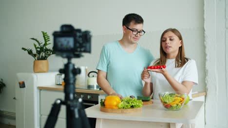 Mädchen-und-Kerl-Aufnahme-Video-über-Bio-Lebensmittel-mit-Kamera-in-der-Küche-zu-Hause