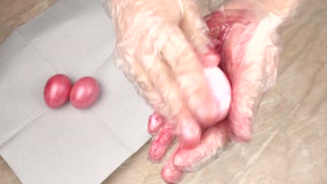 A-person-paints-chicken-eggs-in-pink-pearly-color-for-the-holiday-Easter,-close-up,-preparation,-seasonal