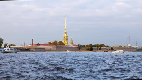 Vergnügungsschiffe-schwimmen-in-der-Nähe-von-Peter-und-Paul-Festung,-Wellen-von-Fluss-im-Vordergrund