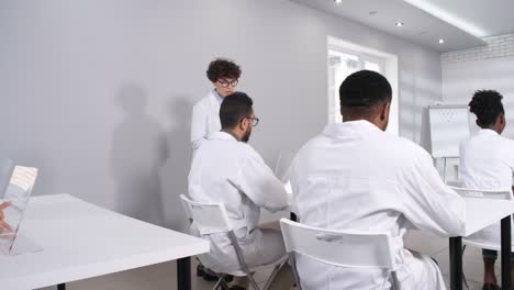 Female-Professor-Checking-on-Students-Working-with-AR-Touchscreen-Devices