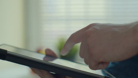 Man-using-tablet-computer-online-shopping-working-from-home.-Close-up.