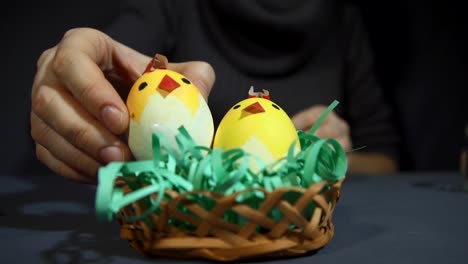 Crear-souvenir-de-Pascua-de-los-pollitos-de-cáscaras-de-huevo-a-mano-sobre-una-mesa-gris.