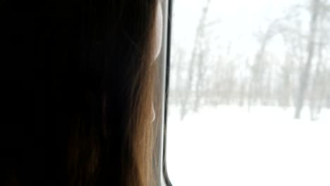 Mujer-joven-viajando-en-un-tren-y-mediante-teléfono-móvil.-Mano-femenina-envía-un-mensaje-desde-el-teléfono-inteligente.-Brazo-de-la-chica-charlando-con-amigos.-Cierre-para-arriba