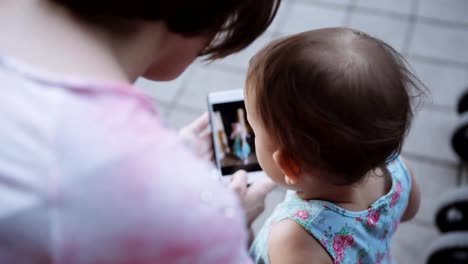 Woman-showing-something-to-her-child-on-the-smartphone.