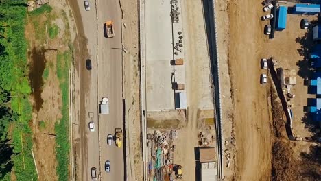 aerial-shot-of-construction-of-highway-in-russian-city,-camera-looking-down-and-moving-along