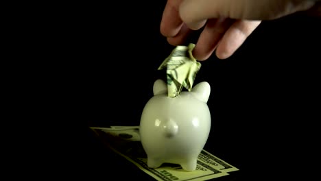 Piggy-bank-and-dollar-bills-turn-on-a-black-background