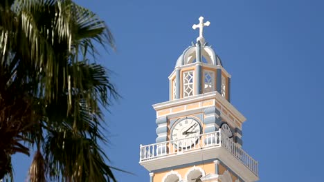 Torre-de-reloj-de-la-iglesia-contra-el-cielo-azul-en-Fira,-Santorini,-turismo-y-religión