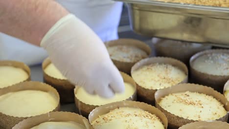 Pastry-Hände-Chef-Mandeln-und-Nüssen-Körner-auf-Teig-für-Ostern-Kuchen-süß-brade