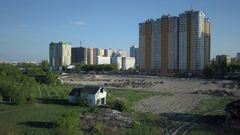 Luftaufnahme.-Alte-verlassene-Gebäude-befinden-sich-in-der-Nähe-der-Baustelle-und-ein-neues-Stadtviertel-mit-Wohnhochhäusern.-Stadtrand-von-einer-Megacity.-Kiew,-Ukraine