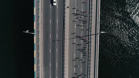 4K-Aerial-drone-fooage.-Marathon-running-on-the-bridge.-Vertical-dolly-shot-top-view