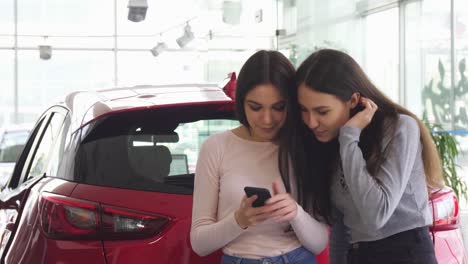 Fröhliche-Freundinnen-unter-Selfies-in-der-Nähe-der-Neuwagen