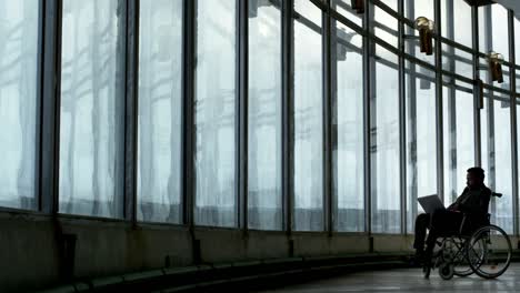 Paraplegic-Businessman-Working-before-Panoramic-Windows