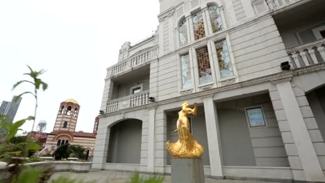 Golden-statue-of-woman-on-Batumi-square,-old-town-architecture,-history-and-art