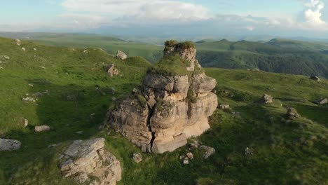 Flying-around-a-large-rock-formation-standing-at-the-foot-of-the-epic-edge-of-a-rocky-plateau.-Russia.-North-Caucasus