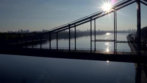 Aerial-shooting-pedestrian-bridge-of-Kiev-on-sunrise.-Summer-morning-in-Kiev-Dniepeer-river.-Ukraine.-European-city