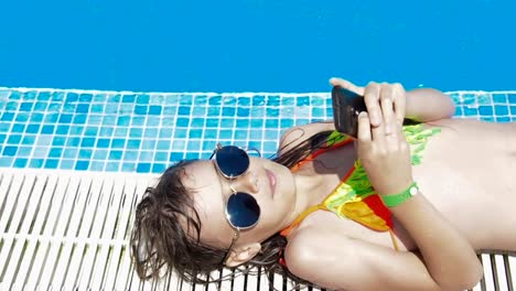 A-child-by-the-pool-with-a-phone.