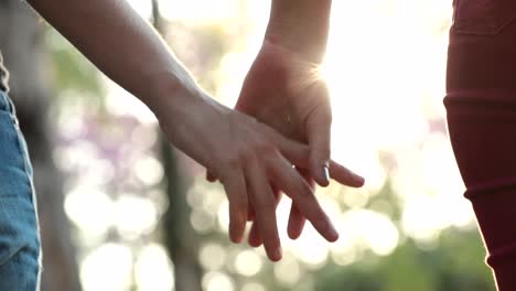 Close-up-of-hands-joining-together-with-sunlight-flare-in-the-background