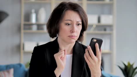 Old-Businesswoman-in-Shock-while-Using-Smartphone