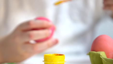 Children-hands-preparing-yellow-paint-to-draw-pattern-on-egg,-Easter-preparation