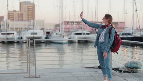 Hermosa-mujer-tener-chat-de-vídeo-usando-el-teléfono-inteligente-al-aire-libre-compartiendo-viajes-naturaleza-vista-con-los-amigos-o-la-transmisión-en-vivo-a-través-de-los-medios-de-comunicación-social.