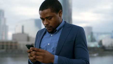 African-Businessman-Chatting-on-Cellphone-in-Evening