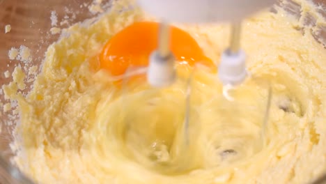 Adding-eggs-to-dough.-Making-cake-in-the-kitchen.