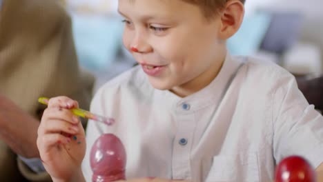 Cute-Boy-Decorating-Eggs-with-Paint