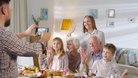 Family-Waving-Hands-and-Smiling-for-Photograph