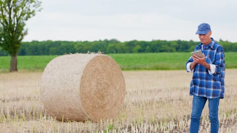 Moderne-Landwirtschaft.-Die-Liebe-zur-Landwirtschaft.-Landwirt-mit-digitalem-Tablet-bei-der-Prüfung-von-Bauernhof