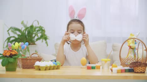 La-pequeña-chica-linda-y-adorable-está-sonriendo-sinceramente.-La-chica-está-jugando-con-una-corbata-esponjosa-en-el-cuello.-La-chica-se-lo-está-vistiendo-debajo-de-la-nariz.